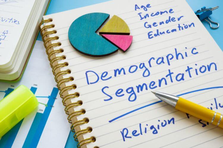 Notebook with handwritten demographic segmentation and pie chart showing targeted marketing breakdown
