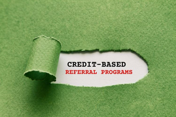 Green torn paper revealing text 'Credit-Based Referral Programs' for secure and ethical incentive models