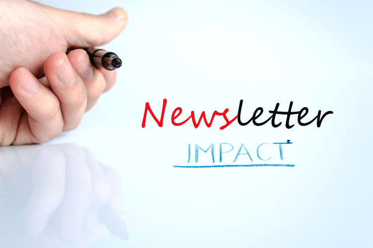 Handwriting 'Newsletter Impact' on glass board, emphasizing measurement of email engagement success