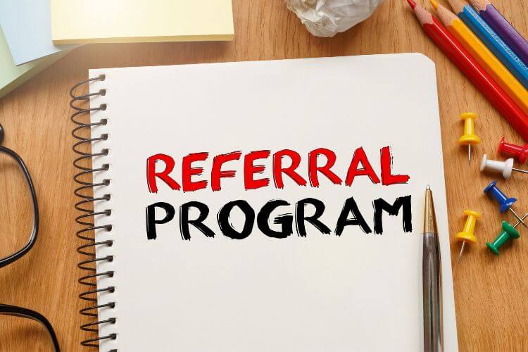 Notebook with 'Referral Program' written in bold red and black, representing challenges in developer-focused referrals