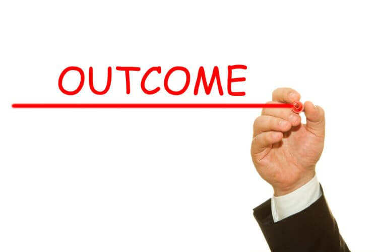 Businessperson writing “Outcome” in red to represent improved marketing results through better targeting.