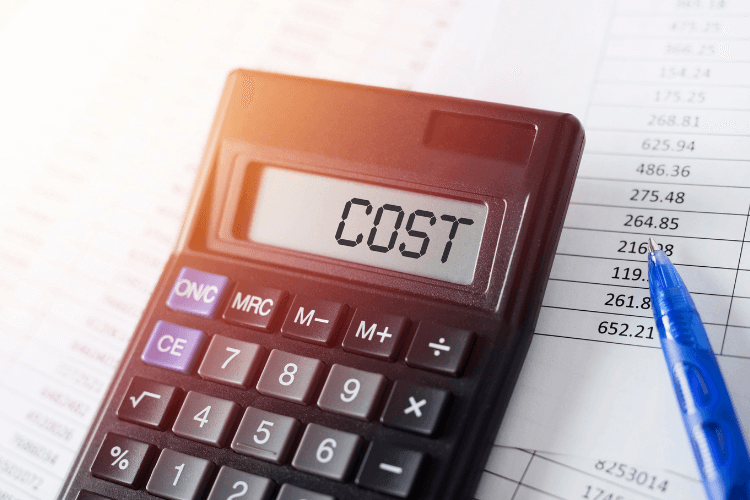 Calculator showing "COST" next to financial spreadsheet and pen, representing budgeting or analysis.