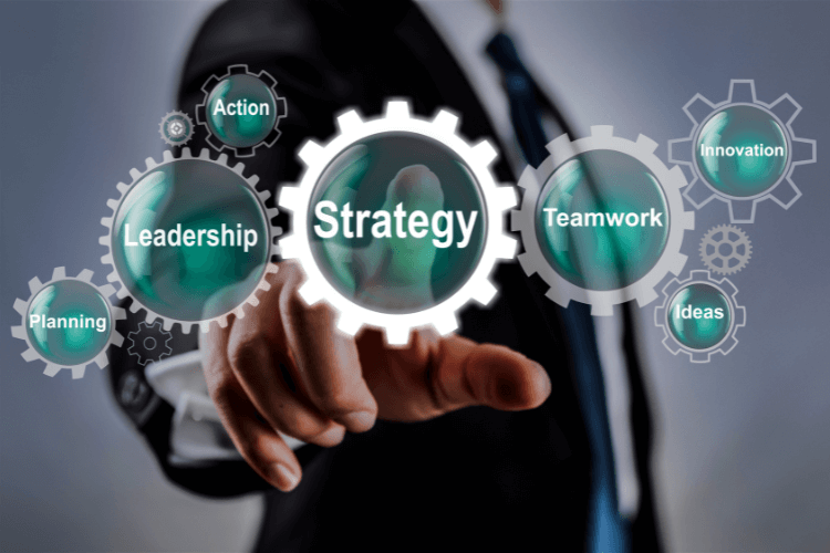 Businessman pointing at virtual strategy interface with gears labeled leadership, teamwork, and innovation