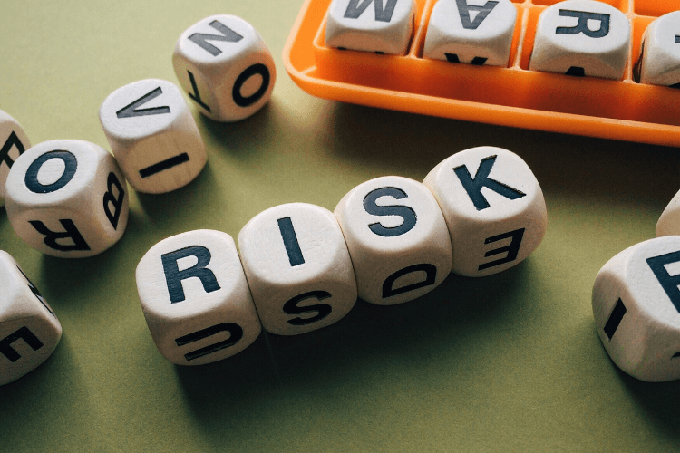 Wooden letter blocks spelling "RISK" representing business or operational risk strategy.