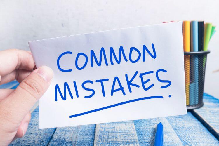 Hand holding a note with text Common Mistakes, highlighting pitfalls in AI and content strategy.