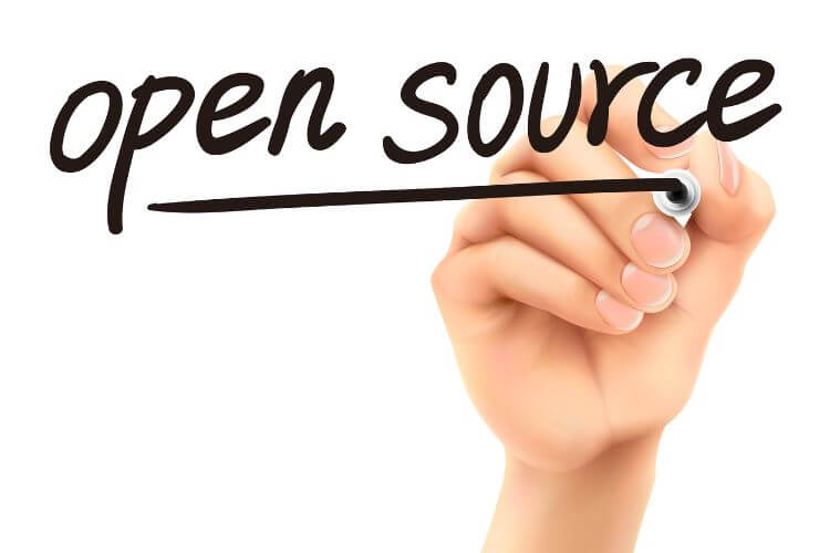 Hand writing open source, highlighting transparency and collaboration in AI model development.