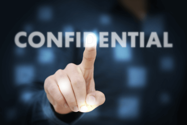 Hand pointing to word confidential symbolizing secure handling of sensitive information.