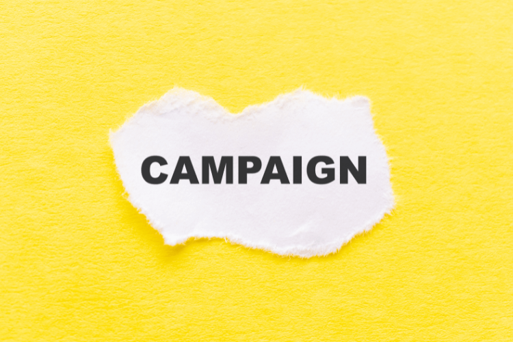 Torn white paper with the word Campaign on bright yellow background for marketing strategy.